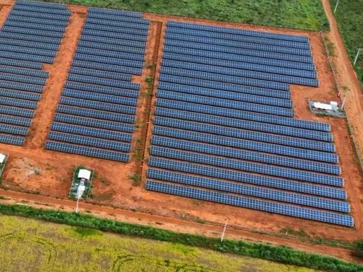 Fileiras de módulos fotovoltaicos de uma usina em solo, vista de cima.